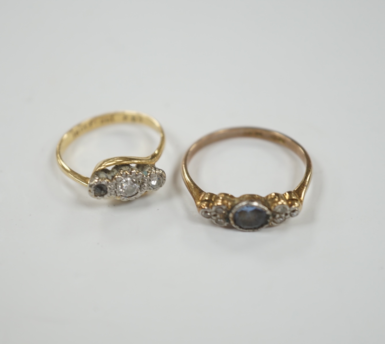 A 1920's/1930's 18ct and plat. single stone sapphire and six stone diamond set dress ring, size P/Q, together with an 18ct, plat and two (ex three) stone diamond set crossover ring, gross weight 5.4 grams.